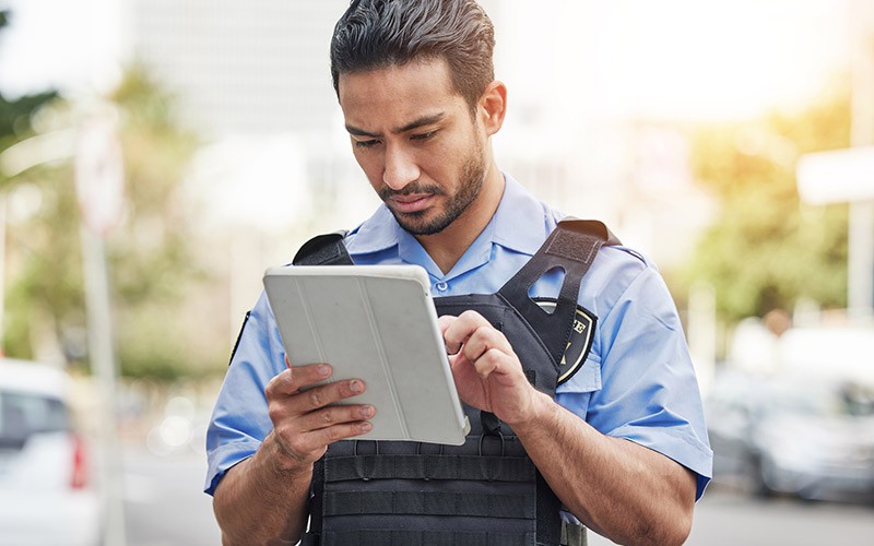 Police officer on tablet device in field