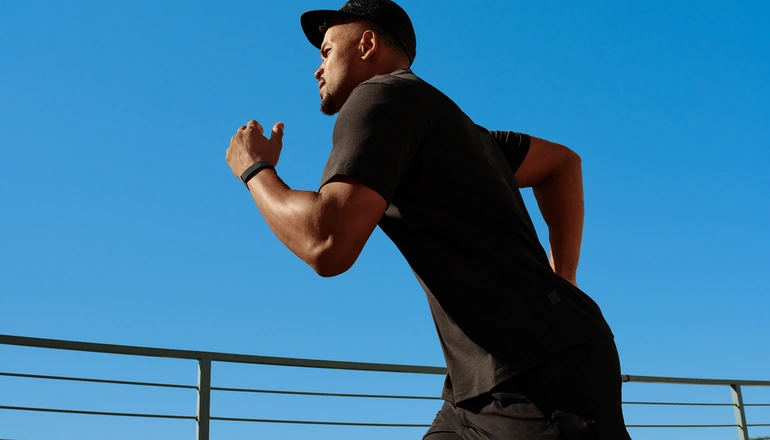Man running with a fitbit on.