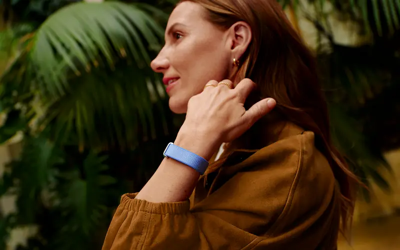 Woman running in the city with Fitbit device