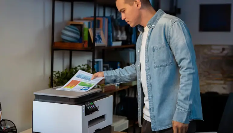 Man taking paper off of a HP printer.