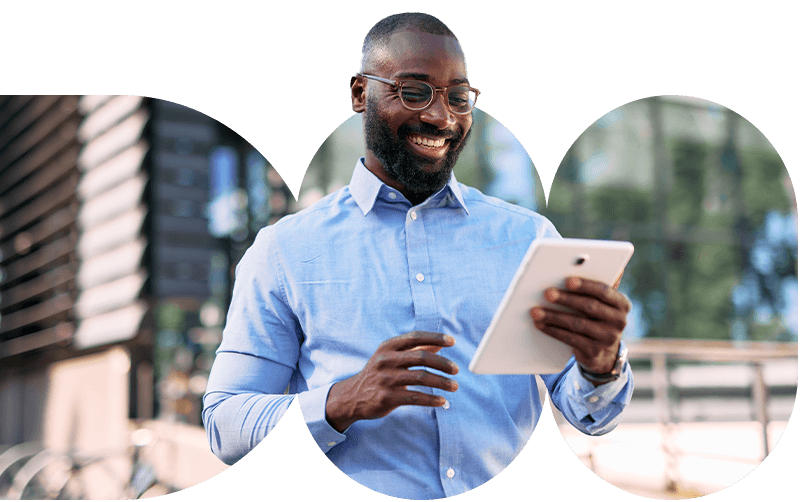 Focused man holds a tablet and looks at the screen, appearing engaged and productive in a professional or casual tech setting.
