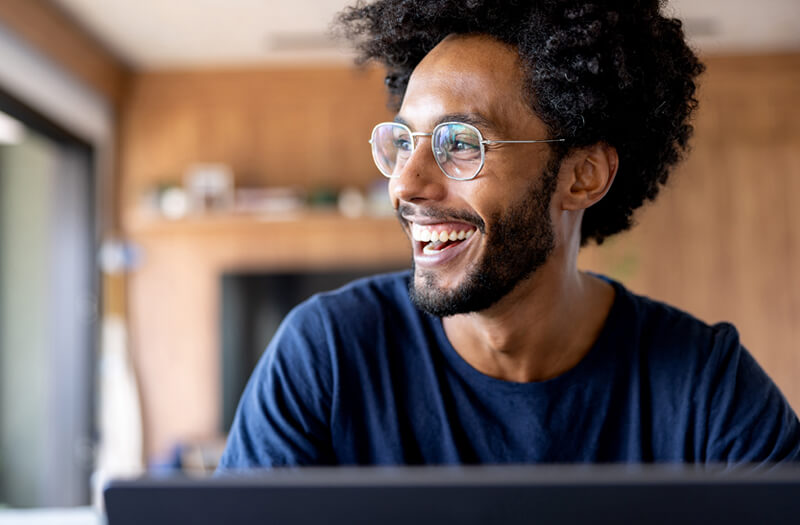 Happy businessman smiling while workign off secure computer using Google Cloud