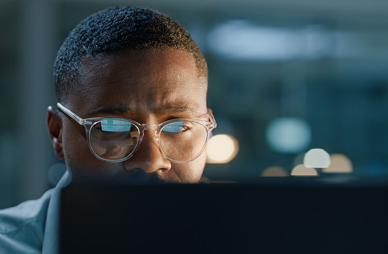 Software programmer working in an office, reading code and solving problems