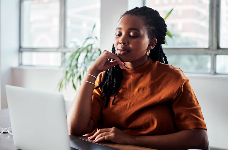 Young business woman working on a laptop, using Claude AI to research, write content, and improve productivity.