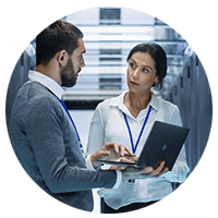 Two IT professionals on computer in data center