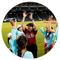 Coach with players at Girls Play Ball event held at DBacks stadium in Phoenix, AZ