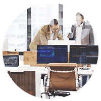 Business professionals talking in front of computer in the office.