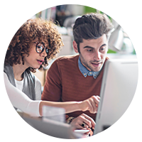 Two business professionals review data on laptop computer