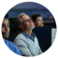 Two business professionals review data on laptop computer