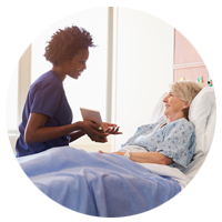 Nurse with tablet shows results to patient in bed