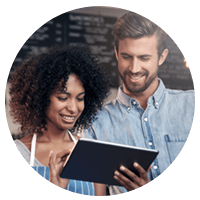 Small business owners looking at data in the cloud.