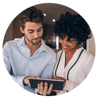 Two small business owners on tablet device in cafe