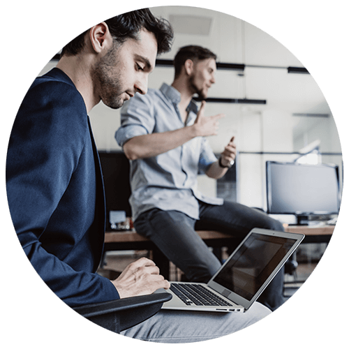 Business team working at their desks on various computer devices