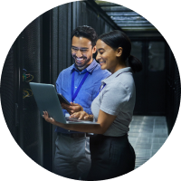 coworkers talking over laptop in server room