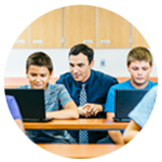 Two K-12 students and a teacher working on devices.