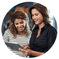 Two woman smiling over tablet