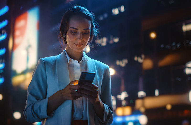 Woman working on technology device at night outside