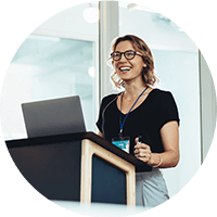 A woman standing while using a laptop