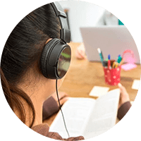 Student reading book while using headset