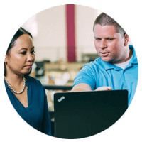 Two business professionals work on laptop computer