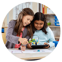 Two student girls collaborating in classroom