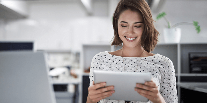 Smiling woman uses tablet device