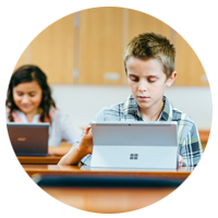 Two elementary grade students looking at laptop computers.