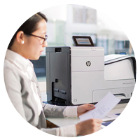 Business woman looking a document just printed on her office printer.