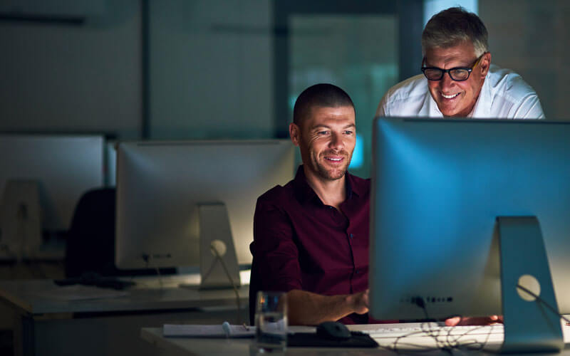 Two men looking over monitor screen