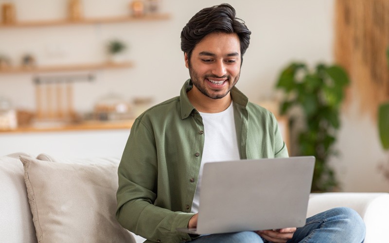 man on couch using laptop