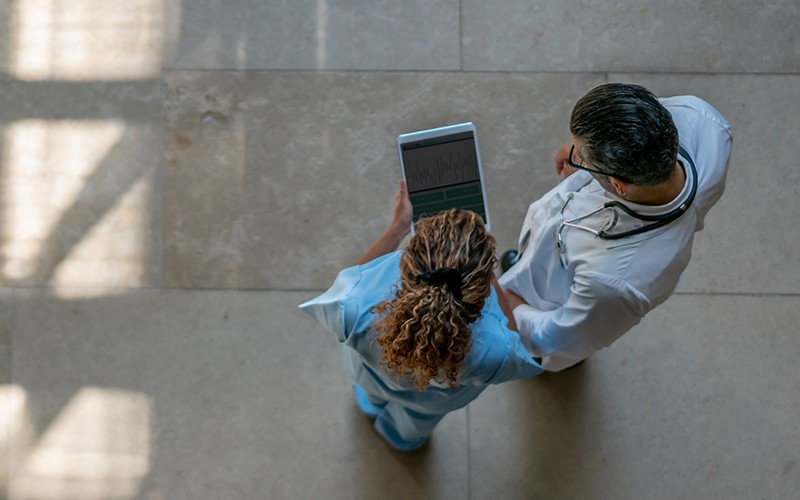 Overhead shot of nurse and doctor talking with tablet