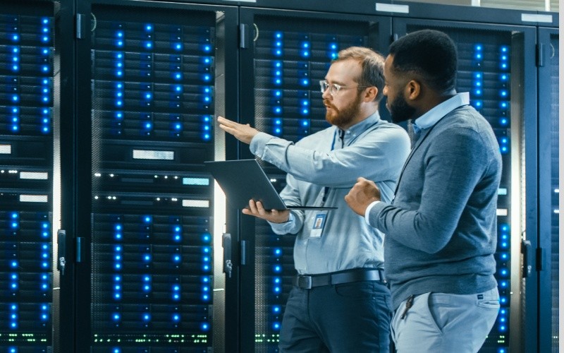 Create more cloud value. two engineers talking in server room