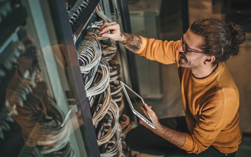 Advanced Load Balancer engineer with laptop working on server