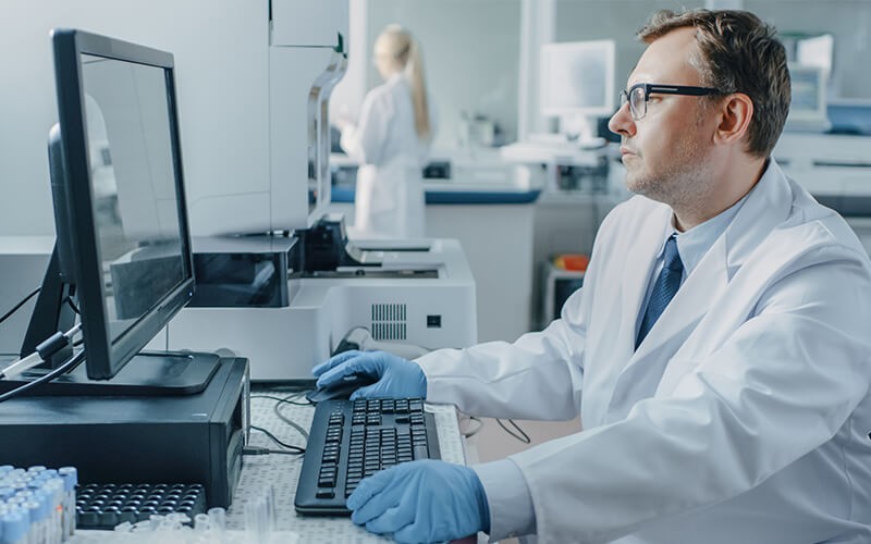 Doctor using a desktop computer in laboratory
