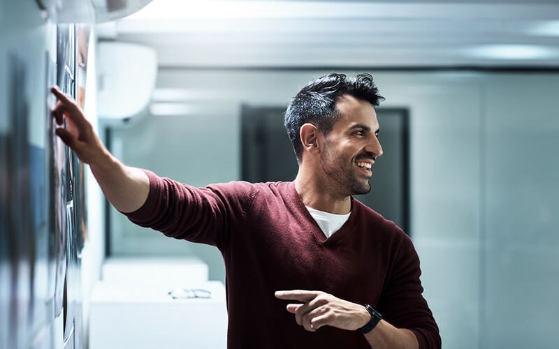 marketing-teammate-pointing-to-asset-on-wall