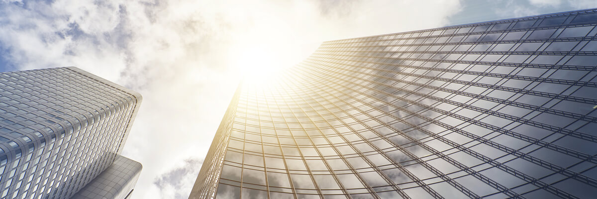 Modern glass high rise business building in clouds