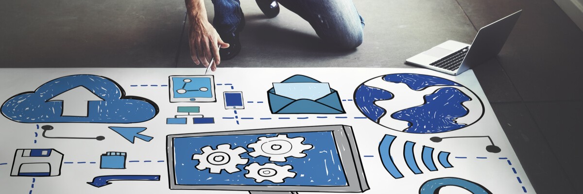 SQL + CSP + SPLA = SaaS Success A man is kneeling on the floor, pointing at a big poster that has graphics of computers, clouds and emails on it.