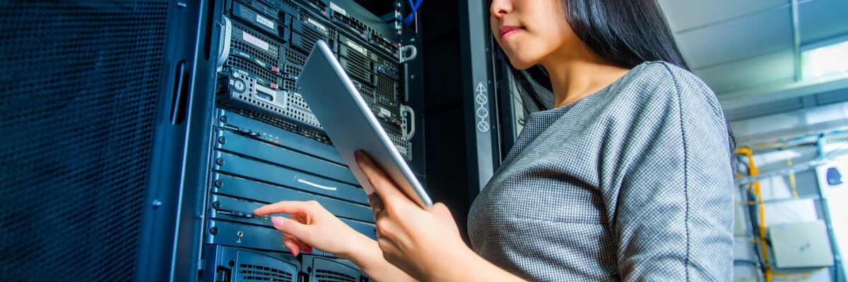 Young engineer businesswoman with tablet in network server room