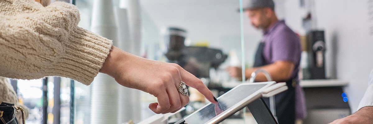 Customer purchasing merchandise and placing signature on tablet computer. Customer experience. Retail tech trends. Retail technology.
