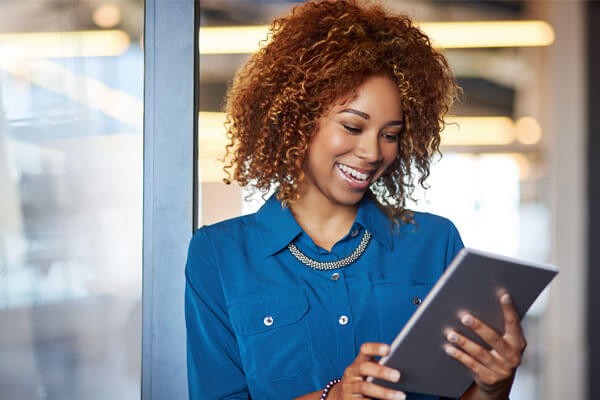 Smiling businesswoman uses tablet device