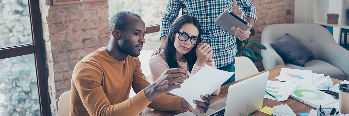 5 Strategies to Turn Digital Disruption Into Business Benefits Three people are working on a laptop