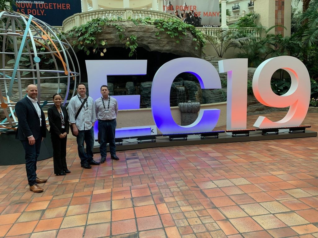 Group of employees in front of Enterprise Connect 2019 sign