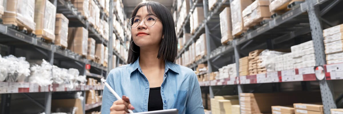 Auditor looking up stocktaking inventory in warehouse store by computer tablet