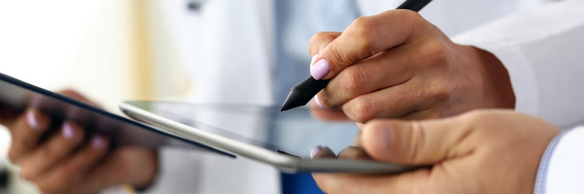 Doctor with patient using Adobe Sign on tablet. Healthcare, healthcare technology, e-signatures, digital forms, digital signatures