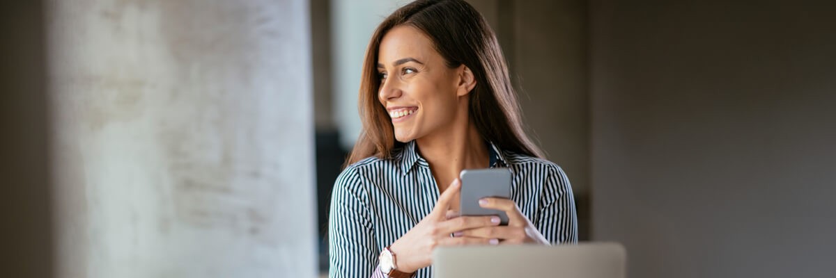 Business woman texting on the phone in modern office