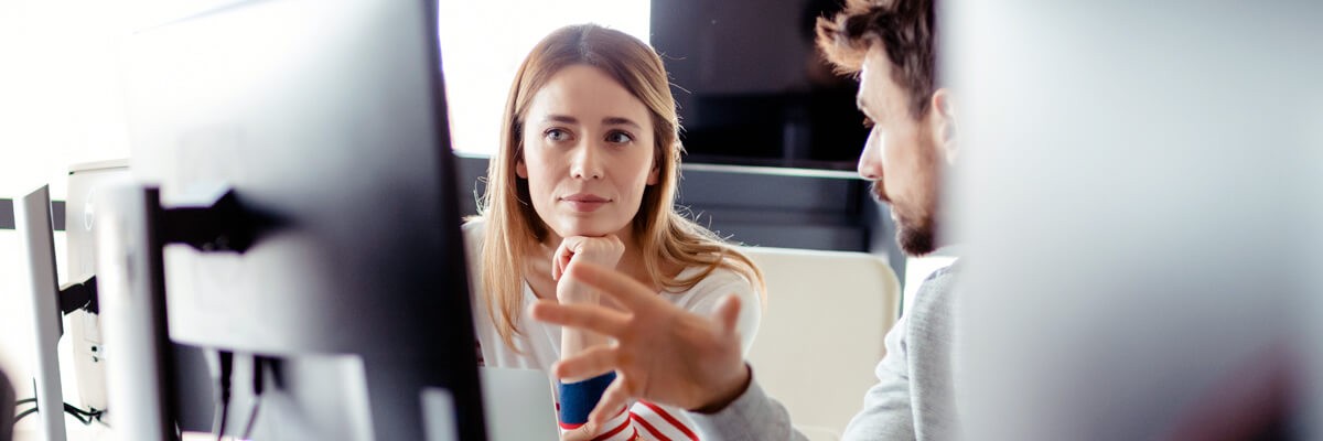 Business team discussion between computer monitors and information technology