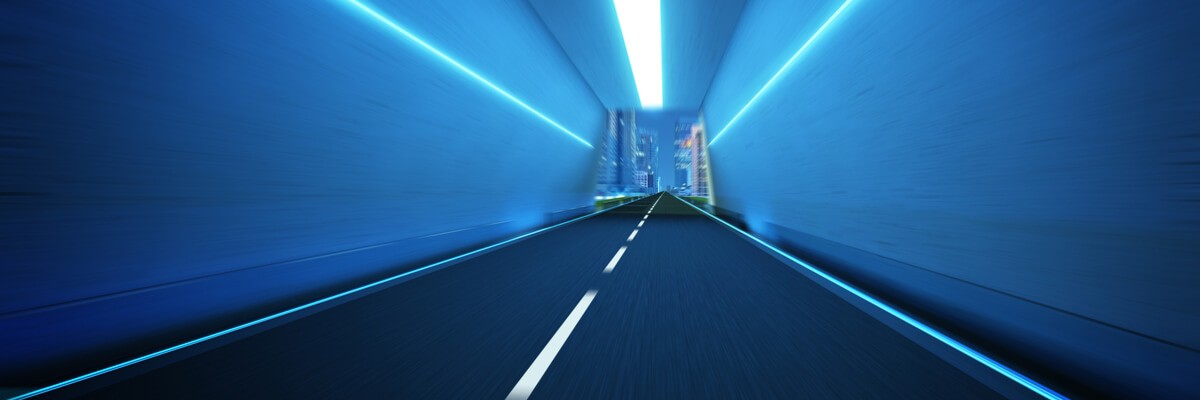 Neon tunnel opening to view of modern city