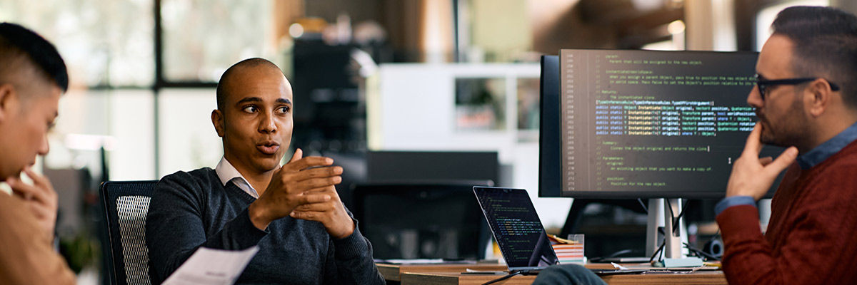 Build Successful LLM Apps by Leading With Evaluations Developers discussing around work desks