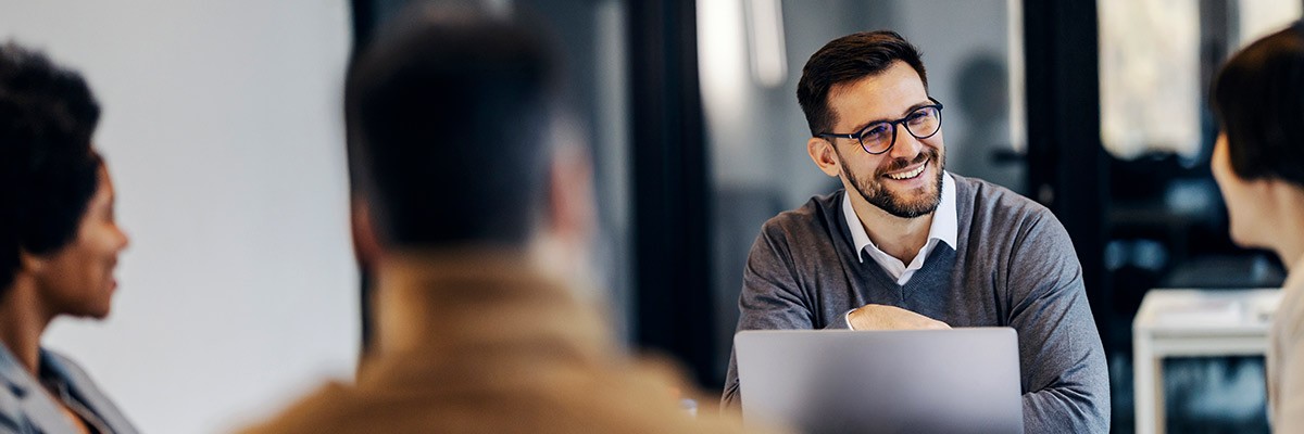 Considerations for Mac in the Enterprise Workers in office with laptops