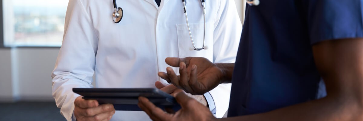 Security Threats — A Threat to Patient Care Doctor and nurse using tablet medical device